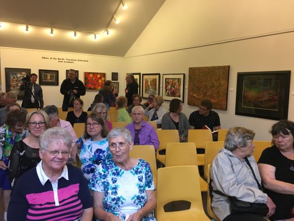 Guests sit in the art gallery as they wait for the questiona and answer session to begin